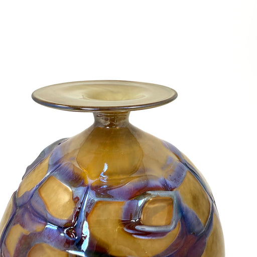 Glass vase with purple and gold swirls on a white background